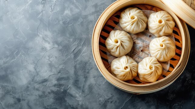 Steamed baozi dumplings stuffed with meat in a bamboo steamer. Gray background. Top view