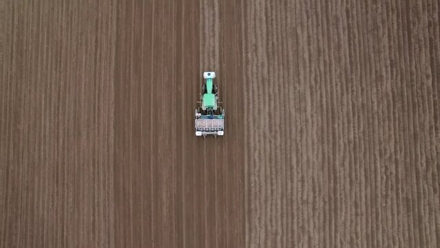 Aerial Top Forward Shot Of Man On Combine Harvester Harvesting In Field - Bakersfield, California