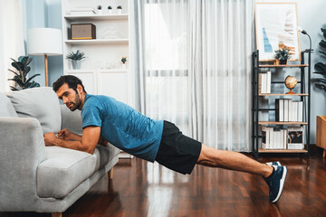 Athletic body and active sporty man using furniture for effective targeting muscle gain exercise at gaiety home exercise as concept of healthy fit body home workout lifestyle. - obrazy, fototapety, plakaty