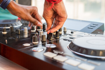 A boy operate turntable dJ mixer on a white table
