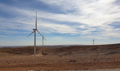 Wind turbine farm producing renewable energy in remote desert landscape of Jordan, Middle East
