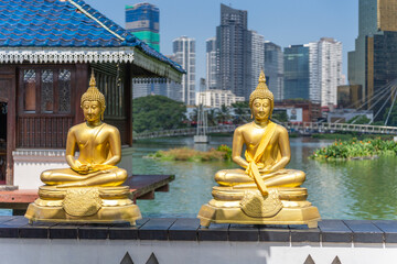 Two golden buddha statues in a park on the lake in Colombo, Sri Lanka