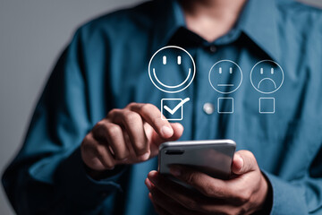 Customer satisfaction service concept. Person use smartphone rating satisfaction by smiling face, on online application. satisfaction feedback review, good quality most.