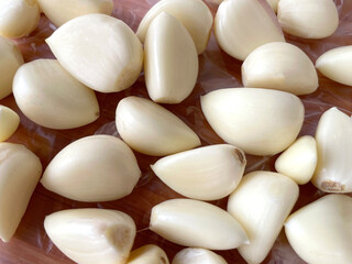 Several peeled garlic cloves are prepared as a cooking spice