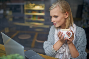 Coffee shop, laptop and woman online for remote work in window for internet blog, website and...