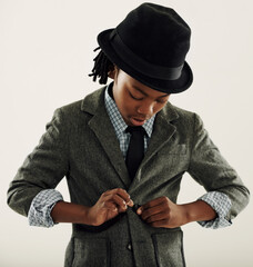 Black child, suit and fashion in studio for vintage style and confidence on a white background. Retro kid or boy check his clothes, coat and fedora hat for fancy character, cosplay and formal