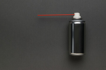 An aerosol can with lubricant and a red tube on a gray background.