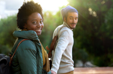 Holding hands, park and happy interracial couple together with smile, bag and morning commute to...