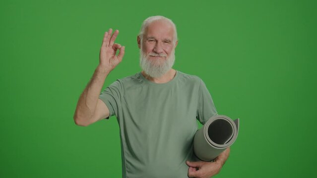 Green Screen. Portrait of Sporty Old Man with Sports Mat Showing Okay Sign. Smiling Elderly Man Likes to Keep Fit.Sports Nostalgia and Memorable Moments.