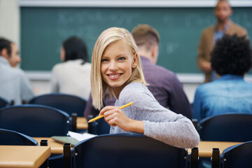 University student, portrait and smile at classroom desk in London for english lecture, education...