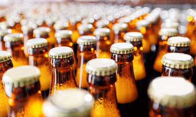Beer brewery industry manufacturing. Brown glass bottles on conveyor belt with sunlight