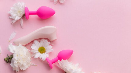 Top view Different set sex toys for woman on pink background with flowers with copy space. Sexshop advertising banner