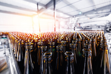 Beer brewery industry manufacturing. Brown glass bottles on conveyor belt with sunlight