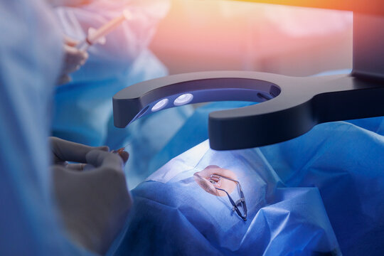 Process lasik treatment, laser vision correction. Doctor use equipment for fixing eyeball, patient under sterile cover