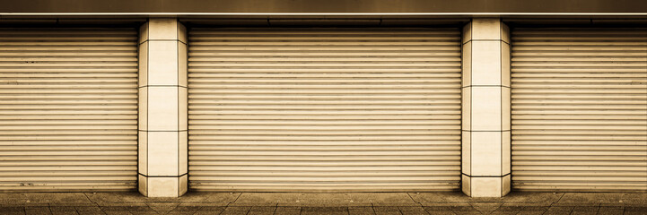 closed steel shutter door, old weathered door of warehouse, storage or storefront for metal door background and textured.