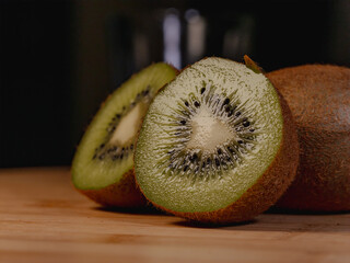 kiwi fruit on a wooden table cut in half 
