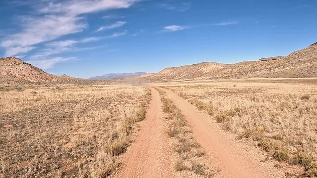 Off road recreation desert trail valley Utah POV. Off road trail riding in 4x4 all terrain vehicle for sport recreation. Utah and Arizona landscape. Grass lands, rocky terrain and mountain valley. 