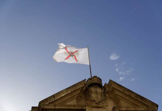 ronda,malaga,spain,02-08-2024 flag of the Real Maestranza de Caballeria de Ronda waving in the wind with a blue sky in the background.