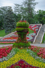 Flower alley in the park with a stone staircase in the background