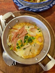 Panned eggs is fried egg topping with bacon and sausage,in the pan. Served with hot pan, famous in north eastern Thailand and Vietnam