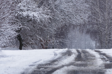 Winter landscape, snow-covered road running through the forest