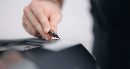 Master uses knife for cut edge of protective vinyl film behind of car part. Transparent protection...