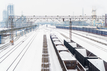 Fototapeta premium Coal and cargo transportation at railway stations on snowy days