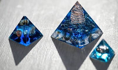 Isolated close up of three beautiful blue orgone generator pyramids- Israel