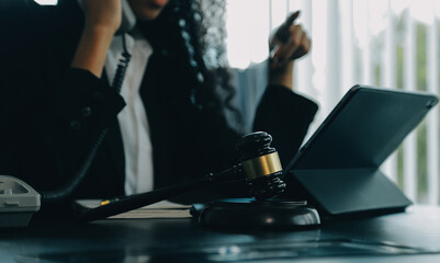 Judge gavel with Justice lawyers having team meeting at law firm background. Concepts of Law and Legal services.