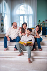 Happy Indian Family of four looking at photo album