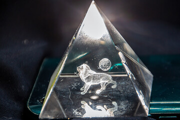 Transparent glowing triangle with a 3D lion inside, close-up