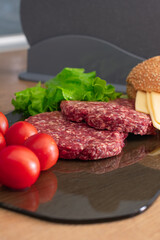 Beef cutlet for burger, tomatoes, cheese and lettuce. Burger ingredients