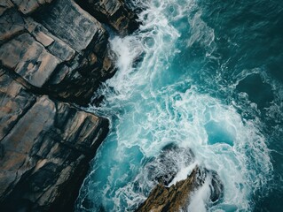 Top-down view of a rocky coastline with crashing waves