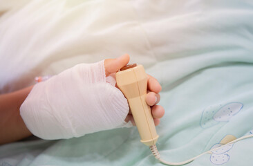Patient with IV solution drip press the help button for nurse calling in case of emergency in the hospital.