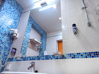 Stylish modern bathroom, white sink with blue and white mosaic tiles