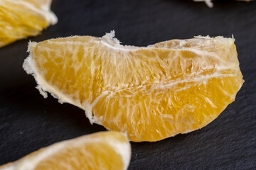 peeled slices of ripe and juicy orange close-up