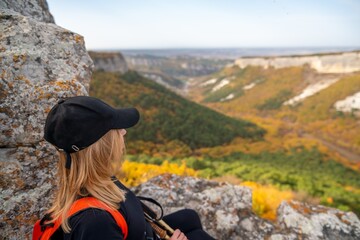 woman backpack on mountain peak looking in beautiful mountain valley in autumn. Landscape with sporty young woman, blu sky in fall. Hiking. Nature