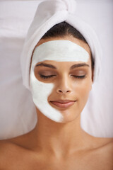 Woman, face mask and wellness with skincare in spa, detox and cosmetic treatment for kaolin facial. Person, relax and beauty with natural clay on skin, soothing and cleaning with dermatology on bed