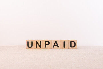 Unpaid word from building blocks on a light background