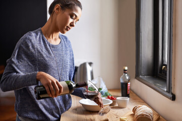 Woman, pour wine and home for dinner, relax for peace and leisure with drink in kitchen. Alcohol, glass and bottle with refreshment, hydration with beverage to celebrate or chill in apartment