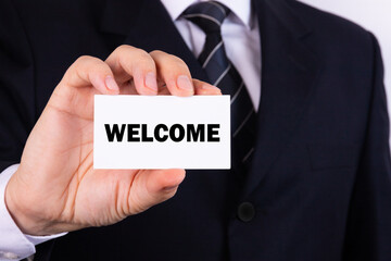 Businessman holding a card with text Welcome