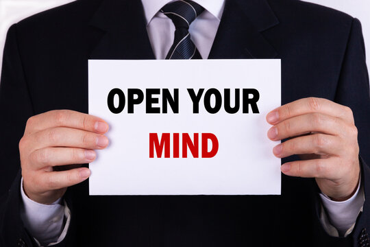 Businessman holding a card with text open your mind