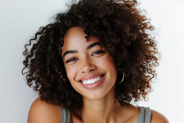 Smiling young woman with curly hair enjoying relaxing moment. Beauty and happiness.