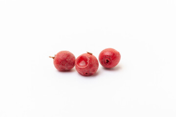 Red peppercorns on white background. Organic spice. Dry red pepper grain. 