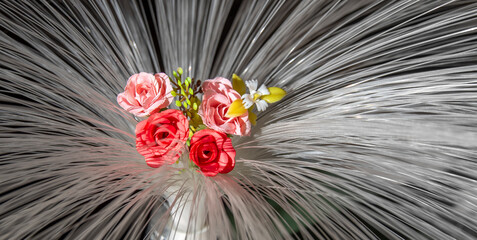 Bouquet of artificial flowers on the background of the optical fibers