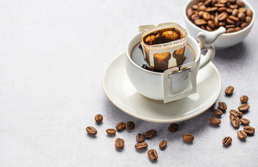 Drip coffee bag with ground coffee in  cup
