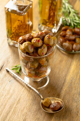 Spicy olives and bottles of olive oil on a wooden table.