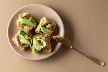 Toasts with pate on a beige background.