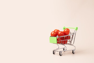 Grocery cart with tomatoes on natural background, fresh produce, supermarket shopping, healthy food