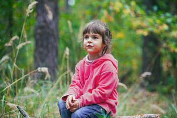 Portrait of a little girl outdoors in the autumn forest